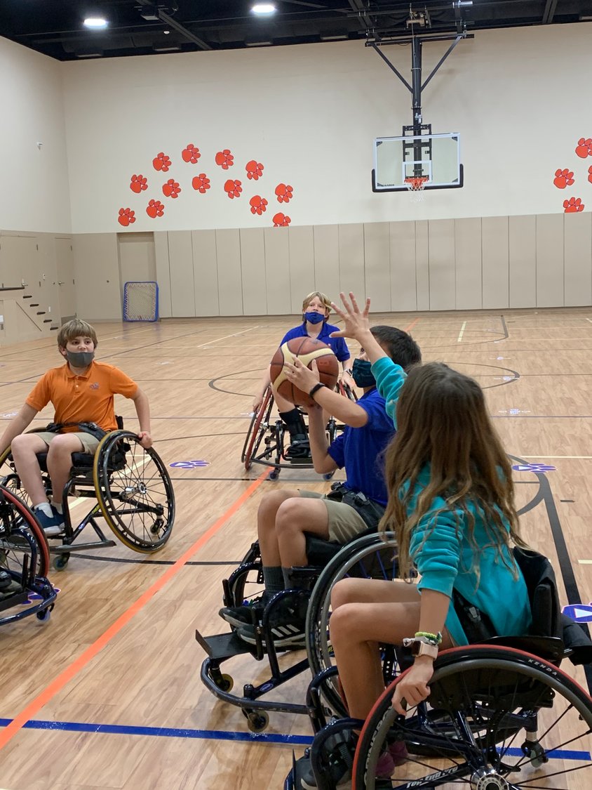 Bolles fourth-graders play basketball from wheelchairs as part of a project to design a plan for athletes of all abilities to play sports together.
